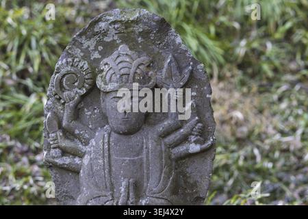 Piccola placca scultorea di Buddha con la figura di Murti, diversi volti e braccia che simboleggiano diversi poteri nel tempio Saigandenji nel piccolo villag Foto Stock