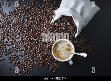 Tazza da caffè, sacchetto e chicchi di caffè sul tavolo della cucina. Vista dall'alto Foto Stock