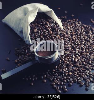 STILL Life con chicchi di caffè tostati, borsa in tela e supporto della macchina per caffè espresso Foto Stock