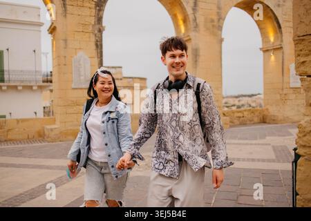 Coppia felice che si diverte a camminare e a parlare per strada Foto Stock