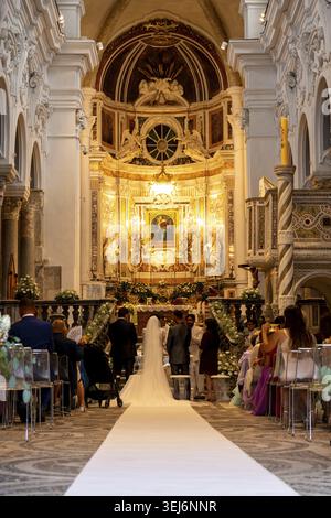 Sessa Aurunca - Campania - Italia - 08-29-2025: Interno della Cattedrale di Sessa durante la cerimonia nuziale, sposa e sposo in piedi all'altare mentre ospiti Foto Stock