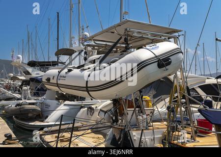 Nydri - Isole Ionie - Grecia - 08-07-2025: Un piccolo gommone è fissato sulla poppa di uno yacht, circondato da diverse barche a vela e motorbo Foto Stock