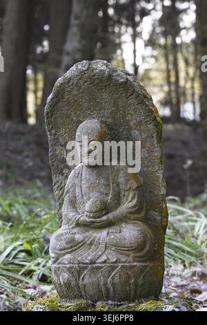 Piccola placca scultorea del Buddha Gautama ricoperta di licheni, tempio Saigandenji nel piccolo villaggio di Aso Kumamoto, in Giappone Foto Stock
