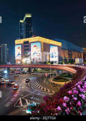 Shanghai, Cina - 4 maggio 2026: Quartiere finanziario di Lujiazui vivace scena notturna con edifici illuminati, un ponte decorato con fiori e traffico cittadino Foto Stock