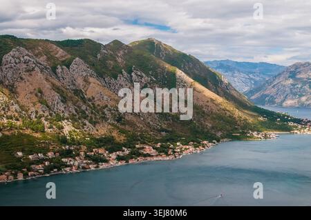 Una splendida vista panoramica ad alto angolo delle massicce montagne rocciose che degradano verso le calme acque blu della Baia di Cattaro in Montenegro Foto Stock