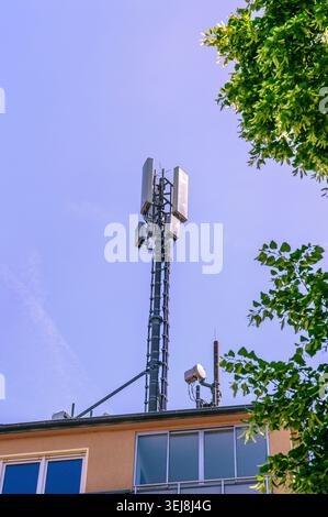 Moderna torre delle telecomunicazioni su un cielo azzurro Foto Stock