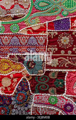 Sfondo tradizionale indiano con tappezzeria patchwork. Primo piano di un tappeto patchwork indiano d'epoca fatto a mano con vivaci motivi etnici e dettagliati Foto Stock