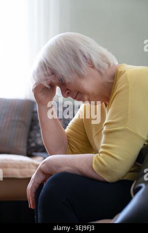 Donna anziana che soffre di mal di testa a casa, ritratto di nonna anziana depressa con emicrania che tiene la testa Foto Stock