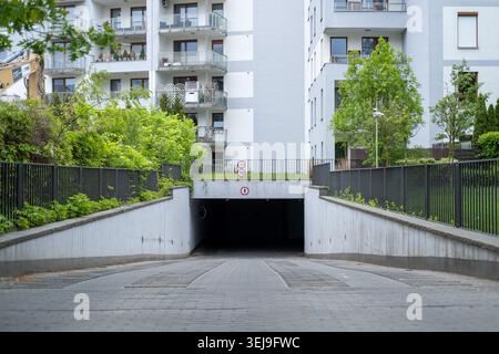Rampa verso il basso per un garage sotterraneo in un moderno complesso residenziale. Foto Stock