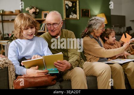 I nonni senior si uniscono ai nipoti durante il gioco creativo Foto Stock