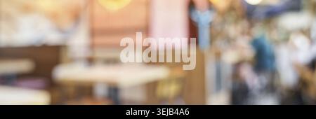 Interni sfocati di un intimo caffè con illuminazione soffusa e calda atmosfera Foto Stock