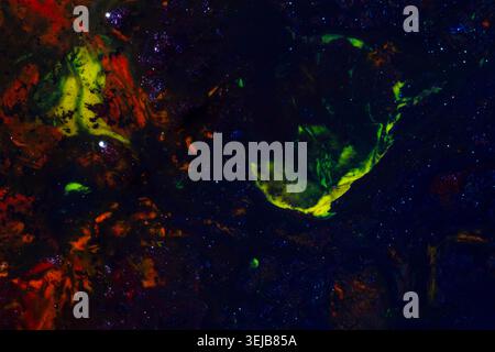 Opere d'arte astratte d'atmosfera con texture fluide verdi e arancioni che emergono da uno sfondo scuro e profondo. I composi cosmici e misteriosi Foto Stock