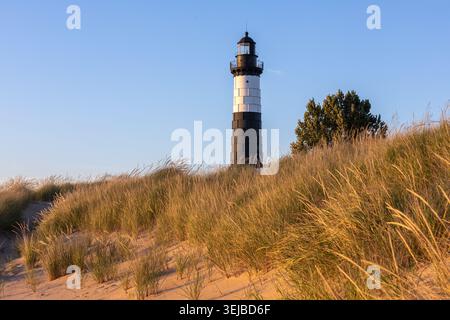 Faro di Big Zible Point al tramonto nel Ludington State Park lungo il lago Michigan, Michigan USA. Paesaggio naturale panoramico con spiaggia e dune di sabbia. Un p Foto Stock