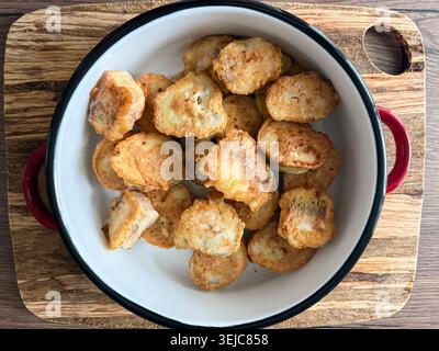 Pepite croccanti fritte servite in una ciotola di smalto Foto Stock