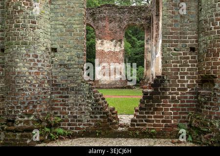 Arcate a strati di mattoni e mura diroccate con felci che crescono alla base delle rovine della Old Sheldon Church, Contea di Beaufort, Carolina del Sud, USA Foto Stock