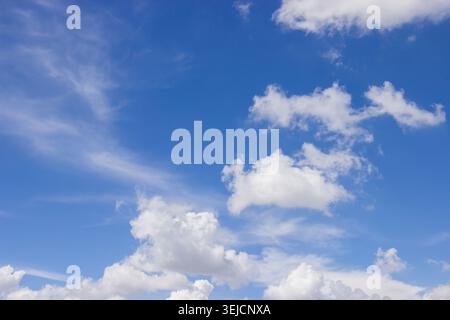 Un bellissimo cielo blu pieno di morbide nuvole cattura la calma e la bellezza di una giornata di sole. Foto Stock