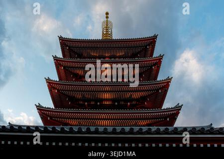 Vista ravvicinata ad angolo basso della pagoda a cinque piani del tempio Sensō-ji a Tokyo, Giappone, sullo sfondo di un cielo semi-nubiloso di prima serata Foto Stock