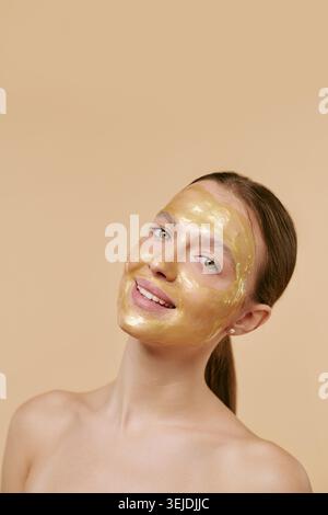 Ritratto di una donna adulta che sorride in maschera facciale di lusso per annunci spa Foto Stock