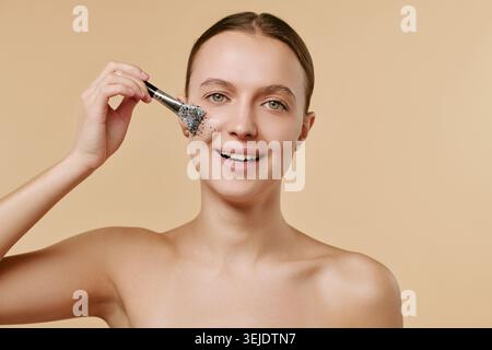 Ritratto di donna adulta che applica la maschera facciale per la cura della pelle Foto Stock