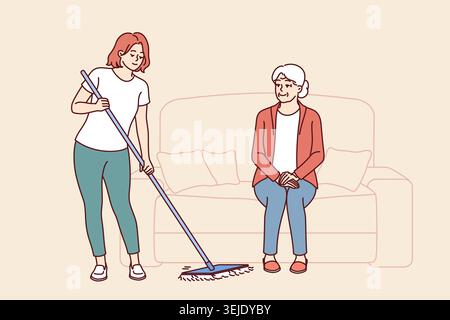 L'assistente della casa di cura sta pulendo il pavimento e si prende cura di una donna anziana seduta sul divano Foto Stock
