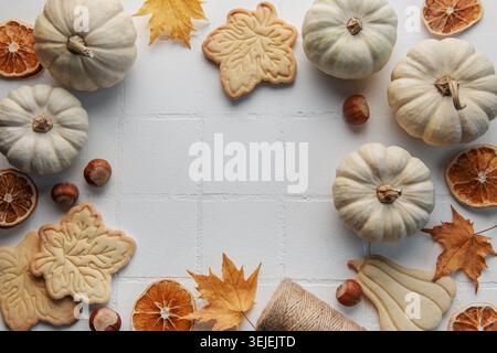 Composizione autunnale. Cornice con zucche, foglie secche, biscotti e noci. Autunno, autunno, halloween, concetto di ringraziamento. La piatta Foto Stock