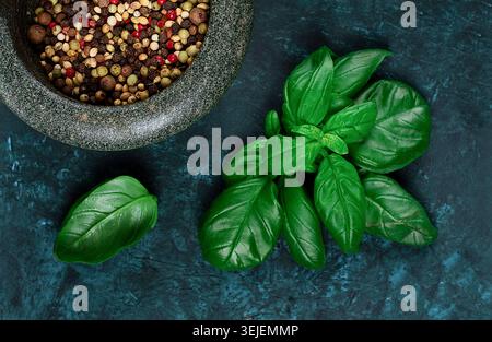 Miscela di peperoni, in mortaio per spezie, foglie di origano, concept, su sfondo verde scuro, vista dall'alto, Foto Stock