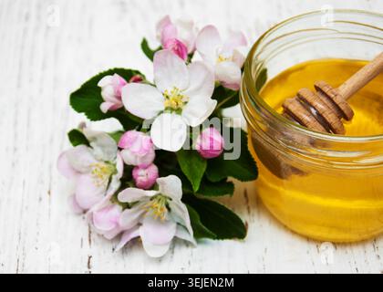 Le mele fioriscono con miele su fondo di legno Foto Stock