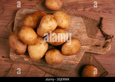 Patate crude, sparse su un tagliere, primo piano, nessuna persona, Foto Stock