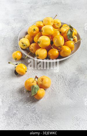 Mele piccole gialle, varietà cinese, su un piatto grigio, vista dall'alto, nessuna persona, Foto Stock
