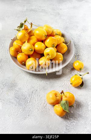 Mele piccole gialle, varietà cinese, su un piatto grigio, vista dall'alto, nessuna persona, Foto Stock