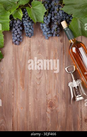 Uva rossa, bottiglia di vino e cavatappi Foto Stock