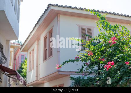 Angolo di casa ottomana rosa con bouganville fiorite nella città vecchia di antalya. Adatto per il patrimonio mediterraneo, immobiliare e contenuti di viaggio. Foto Stock