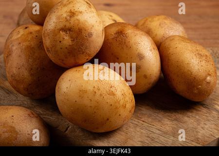 Patate crude, sparse su un tagliere, primo piano, nessuna persona, Foto Stock