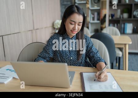 Bella donna d'affari asiatica sicura che lavora con le mani di un computer portatile che digita la tastiera. Investitore professionale che lavora per una nuova Start-up Foto Stock
