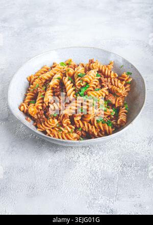Pasta al sugo, pasta con carne macinata, fondo grigio, pasta fatta in casa, fusilli, non c'è gente, Foto Stock