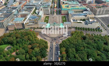 Vista aerea in 4K della porta di Brandeburgo a Berlino, Germania. Paesaggio urbano panoramico con Pariser Platz, il parco Tiergarten e le strade della città. Foto Stock