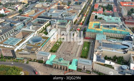Vista aerea in 4K della porta di Brandeburgo a Berlino, Germania. Paesaggio urbano panoramico su Pariser Platz caratterizzato da architettura storica e turisti. Foto Stock