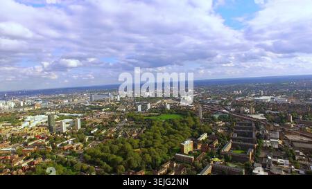 Vista aerea in 4K del sud-est di Londra. Paesaggio urbano panoramico caratterizzato da un verde quartiere residenziale, parco e il fiume Tamigi. Foto Stock
