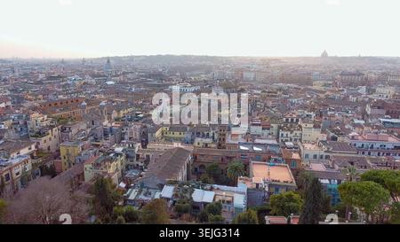 Vista aerea in 4K dei tetti storici e dello skyline di Roma all'ora d'oro, del Vaticano e della cupola della Basilica di San Pietro visibili, Italia. Foto Stock