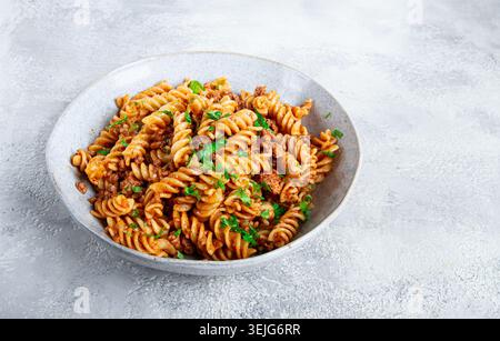 Pasta al sugo, pasta con carne macinata, fondo grigio, pasta fatta in casa, fusilli, non c'è gente, Foto Stock