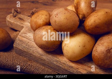 Patate crude, sparse su un tagliere, primo piano, nessuna persona, Foto Stock