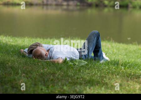 Felice coppia anziana stesa sull'erba Foto Stock