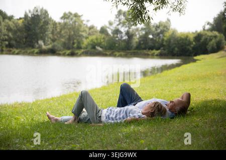 Felice coppia anziana stesa sull'erba Foto Stock
