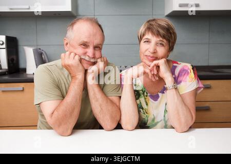 Felicità la coppia senior si siede a un tavolo in cucina Foto Stock