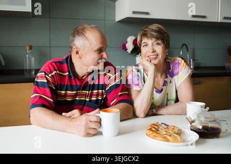 Felicità coppia anziana che beve tè in cucina Foto Stock