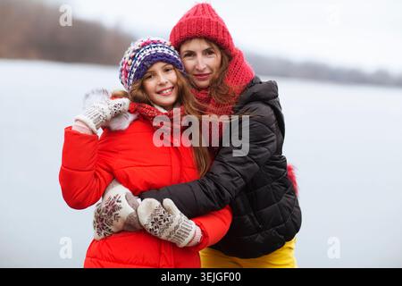 Famiglia madre e sua figlia adolescente in una passeggiata in inverno. Concetto di vacanza invernale attiva. lui è felice di perdersi. Gen Z, dopamina Foto Stock