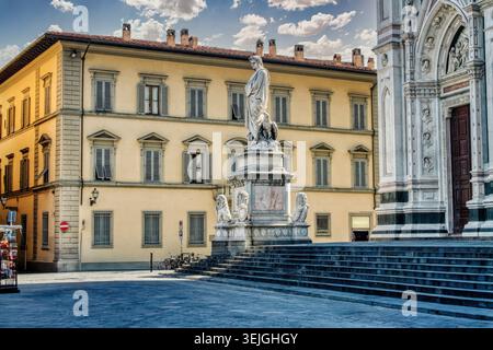 La statua in marmo bianco di Dante Alighieri sorge su un alto piedistallo di fronte alla Basilica di Santa Croce a Firenze. Foto Stock
