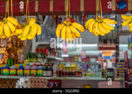 Kuala Lumpur, Malaysia - 22 febbraio 2026: Primo piano di banane appese in vendita al mercato di strada. Foto Stock