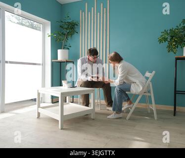 Uomini d'affari che parlano a casa, consulenze a casa. Avvocato o psicologo che parla in un ambiente amichevole Foto Stock