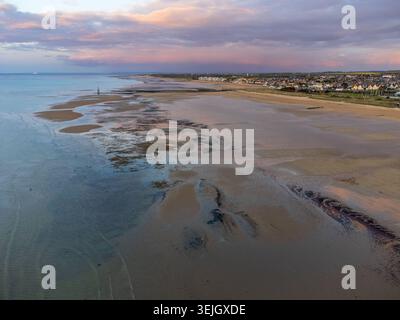 Spettacolare vista aerea di Courseulles-sur-Mer con bassa marea che rivela banchi di sabbia e piscine riflettenti. Sullo sfondo, la città costiera e una bellezza Foto Stock